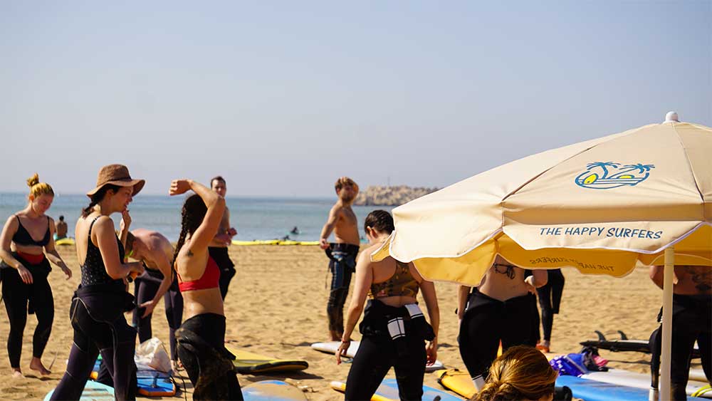 Best surf spots in Morocco for Beginners - 2026 Complete Guide 5 Guests gathering for a surf lesson at Banana Beach, Morocco with The Happy Surfers