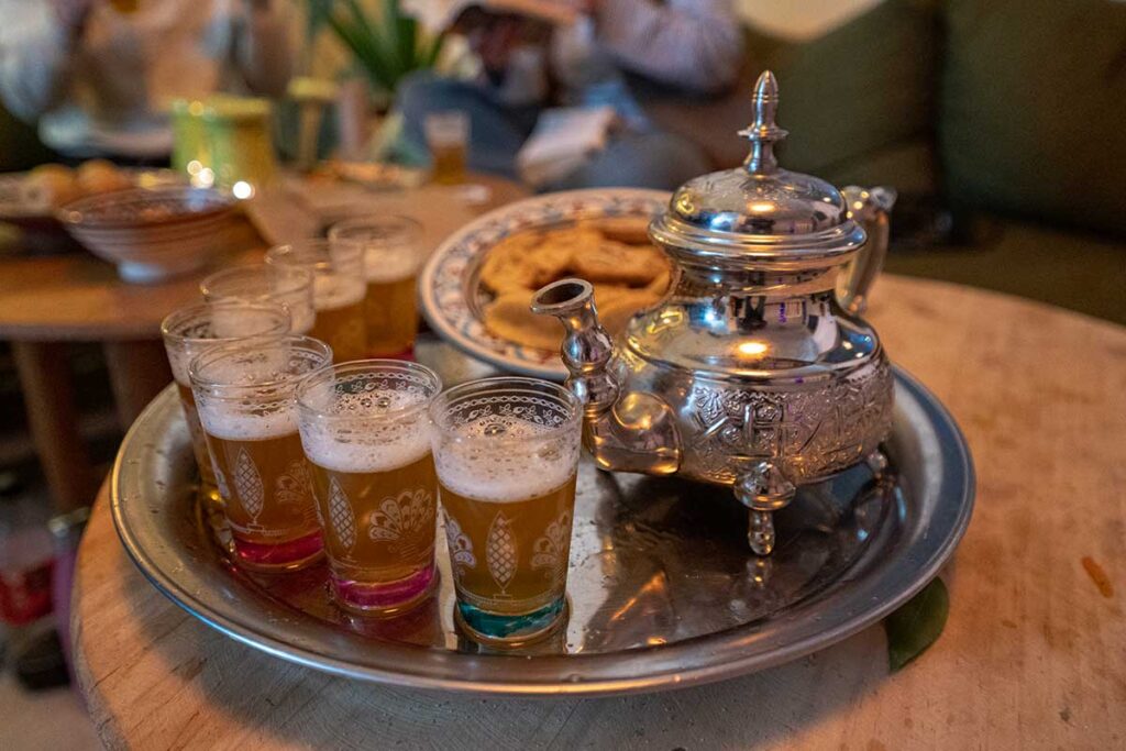Traditional Moroccan tea with mint, glasses, and local biscuits at The Happy Surfers in Tamraght